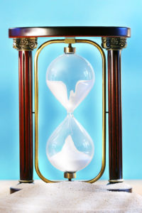 Sand is moving through an hourglass indicating the passage of time.