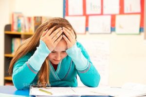 A middle school student is holding her head in her hands while previewing an assignment.