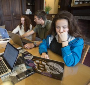 Three Landmark High School students working on laptops.