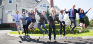 Landmark High School Student Advocates group photo.  The students are jumping in front of an academic building.