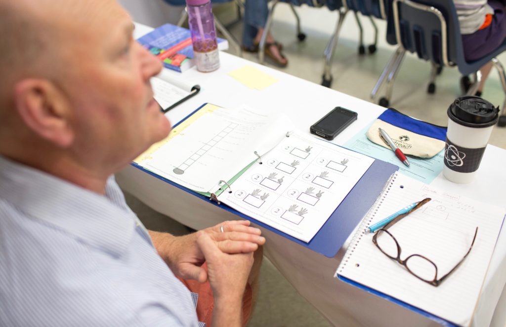 An adult completing a math worksheet.