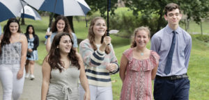 Landmark High School Student Advocates walking on campus with umbrellas.