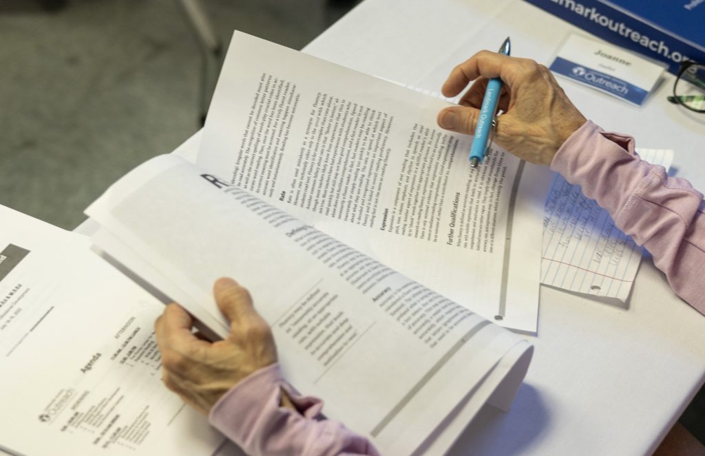 Person holding papers and a pen.