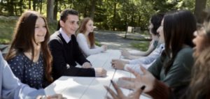 A group of Landmark High School students talking at a picnic table.