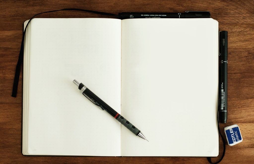 Notebook open, with pen lying across.